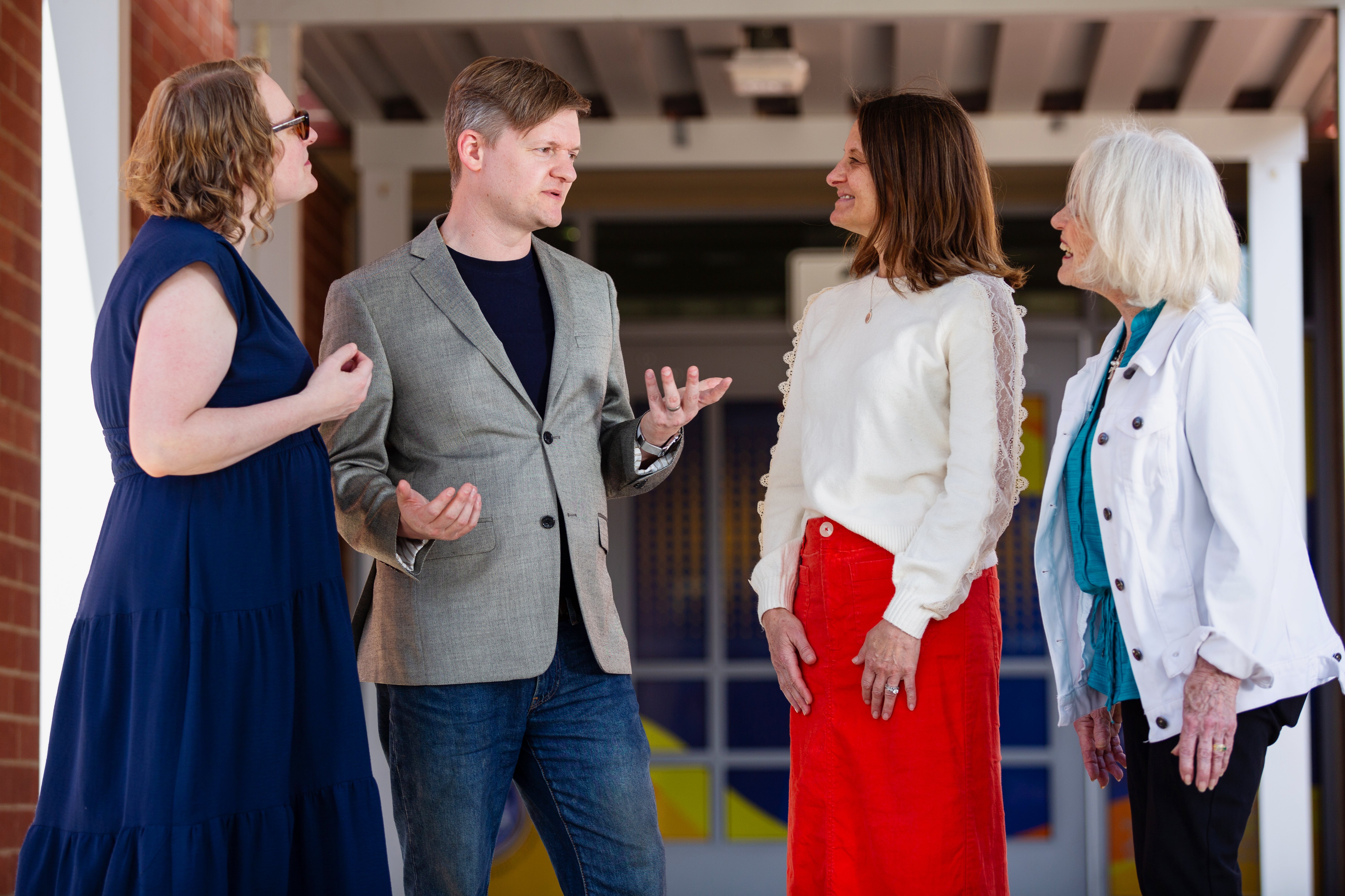 Tim Dorr visiting a school and talking with students and a teacher